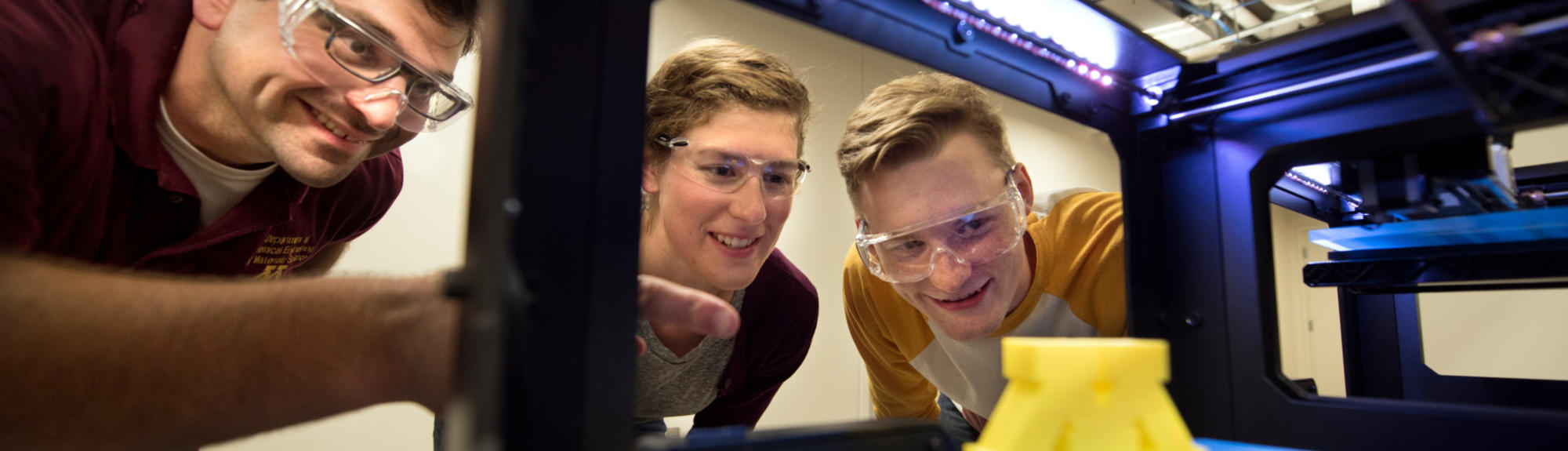 Students inspect a Block M in a 3D printer